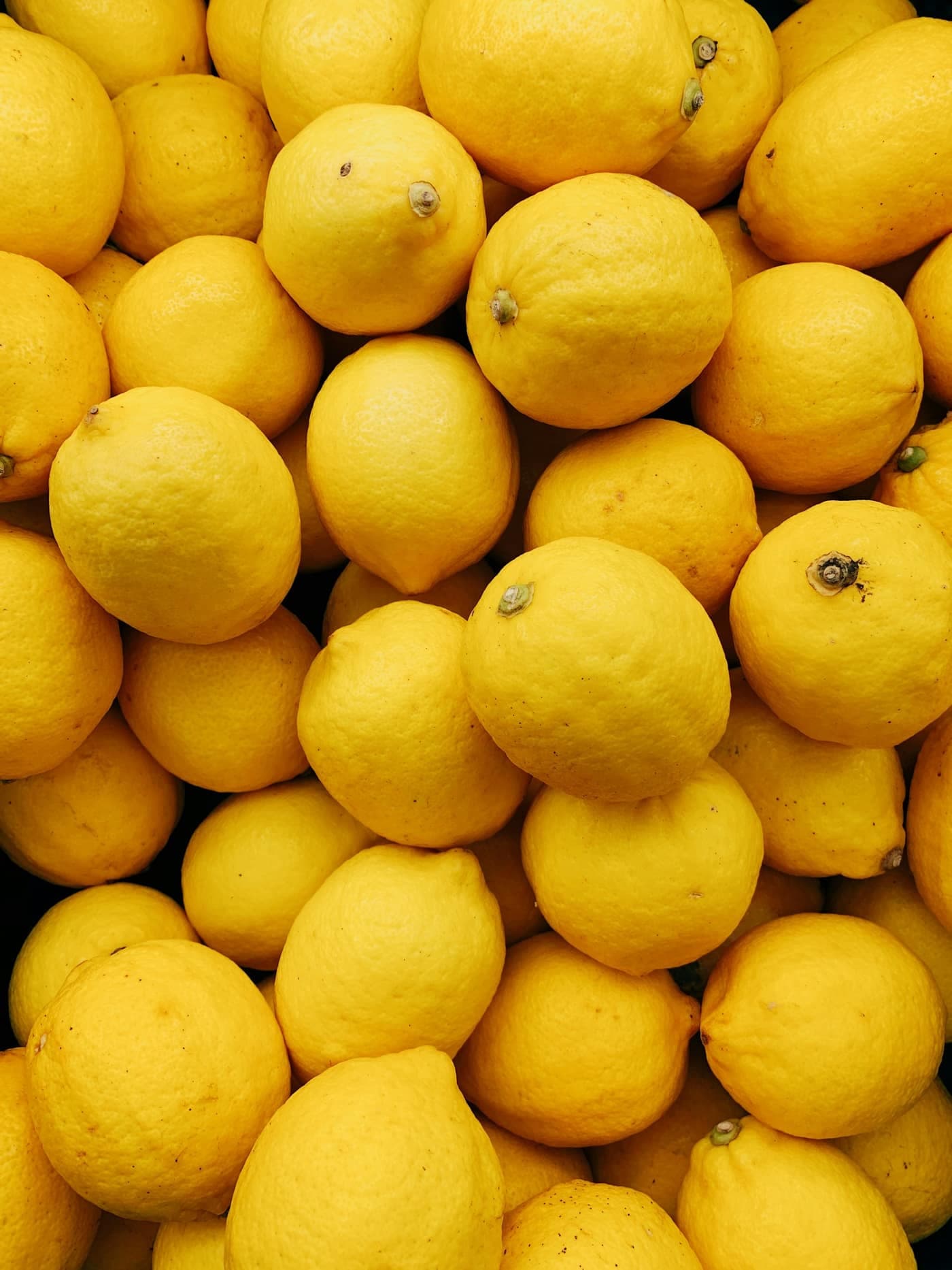 A large pile of bright yellow lemons
